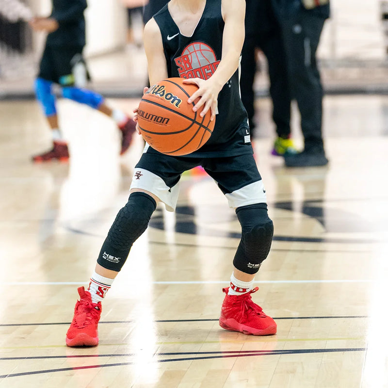 Youth Basketball Player Wearing HEX® Force Leg Sleeves on Basketball Court