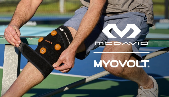 MyoVolt Knee Wrap x McDavid - Athlete Sitting  on Bench Wrapping Knee