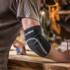 Contractor Using Tape to Mark Length on a Work Bench Wearing the Neoprene Elbow Sleeve with Abrasion Patch