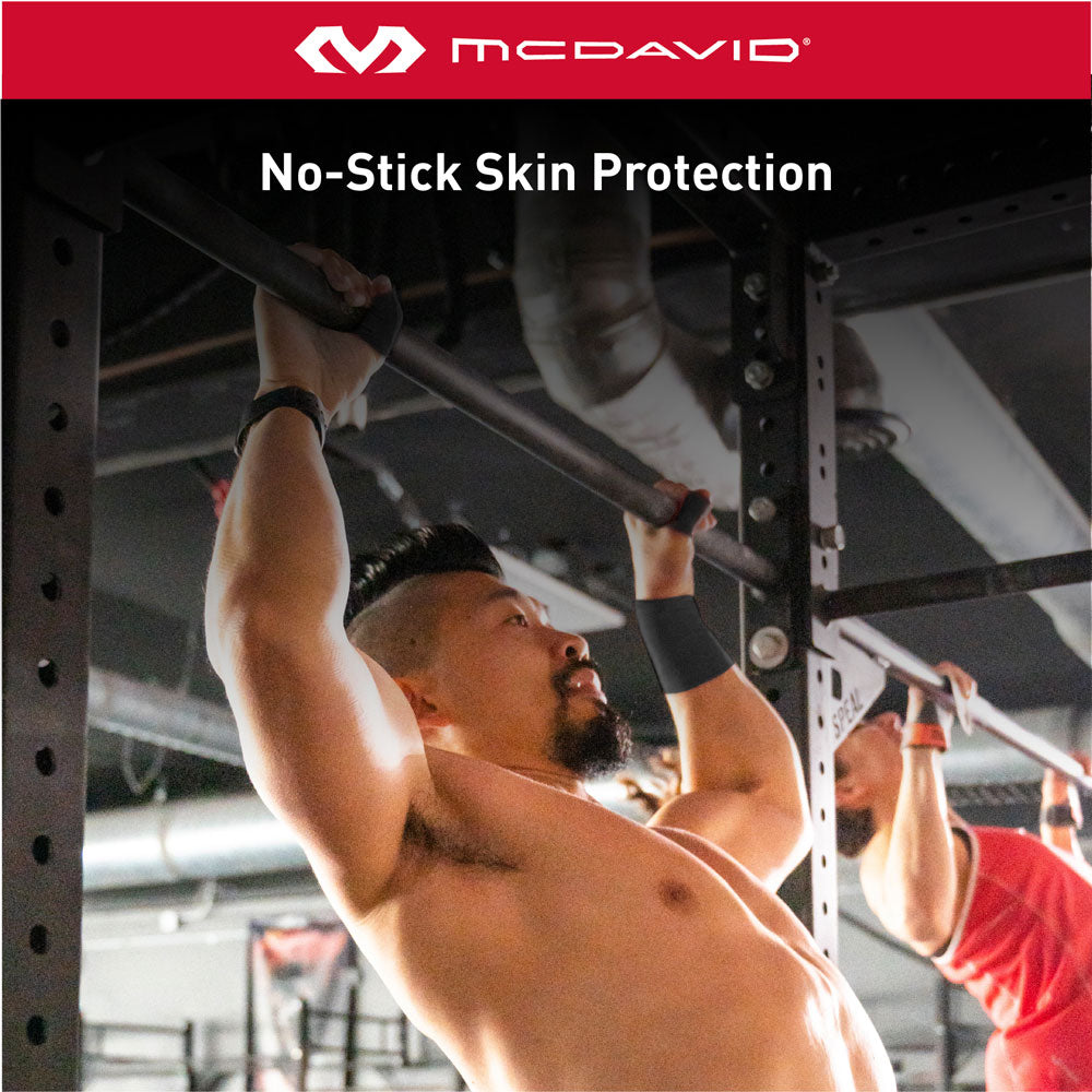 Athlete performing pull-ups wearing McDavid pre-wrap on wrists. Tape provides no-stick skin protection for comfort during workouts.