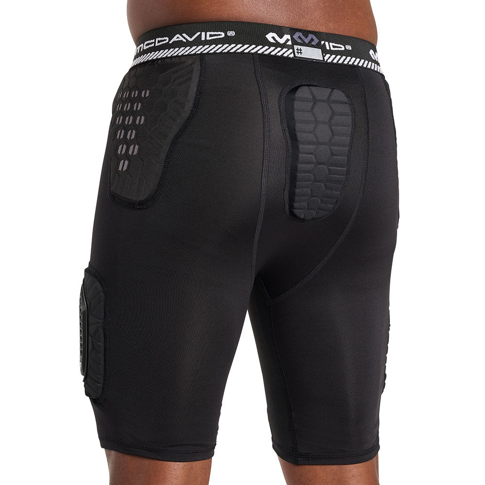 Back view of McDavid HEX® Viz 5-Pad Short with Hard Cap on model, black, showing hex-pattern hip and tailbone pads with McDavid logo waistband