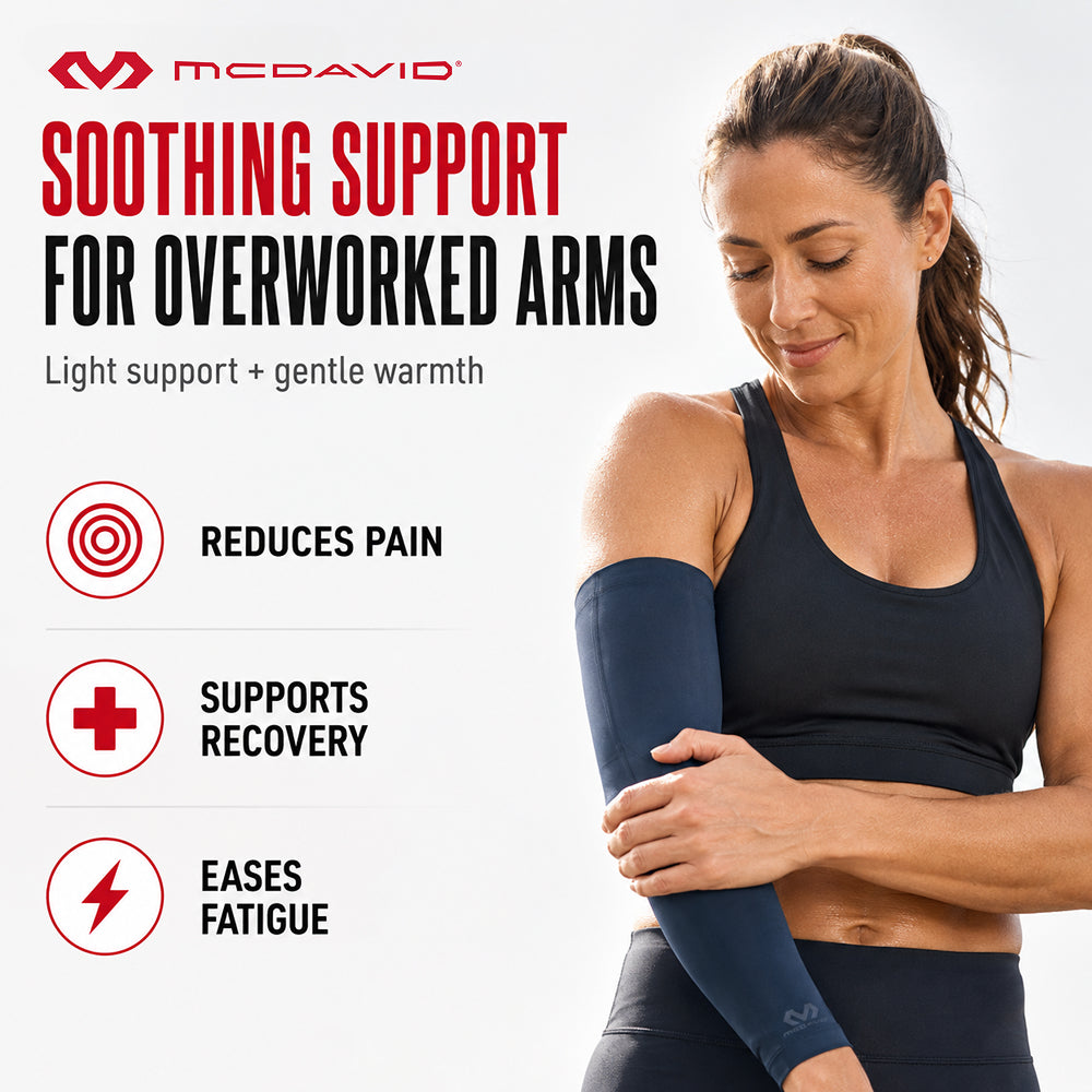 Woman holding her forearm while wearing the Navy McDavid Buttersoft arm sleeve. It gives light support and gentle warmth to help reduce pain, support recovery, and ease fatigue.
