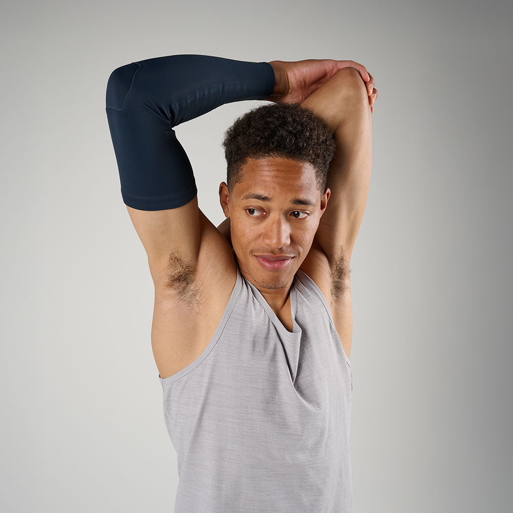 McDavid Infused Therapy Buttersoft Arm Sleeve - Model stretching arms while wearing arm sleeve 