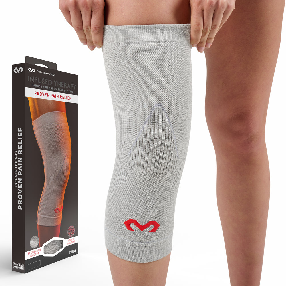 Heather gray Infused Therapy bamboo knit knee sleeve with stays shown next to retail packaging labeled Proven Pain Relief, worn on a person's leg