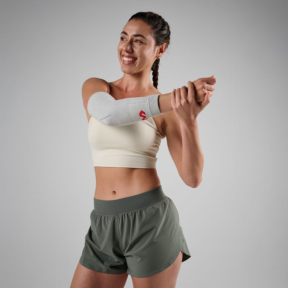 McDavid Infused Knit Elbow Sleeve - Grey- Shown on Model's Elbow While Stretching