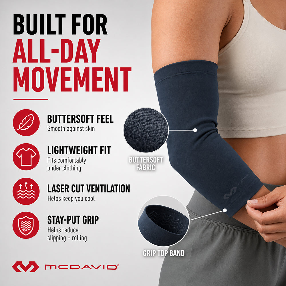 Close-up of the Navy McDavid Infused Therapy Buttersoft Infused Therapy Elbow Sleeve on the arm, showing its soft fabric and grip top band. Features include a buttersoft feel, lightweight fit, laser-cut ventilation, and a stay-put grip.