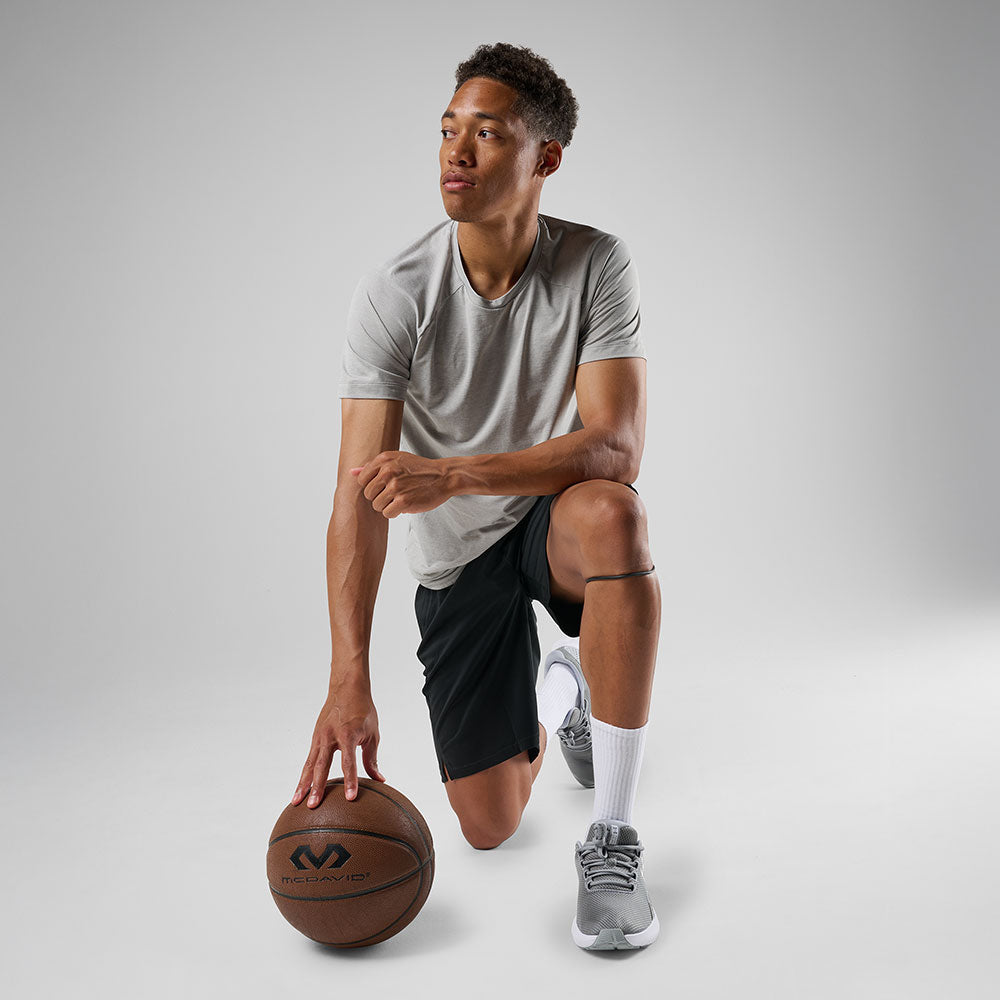 McDavid Silicone Patella Band Pair - Black - Shown on Model Kneeling with Basketball