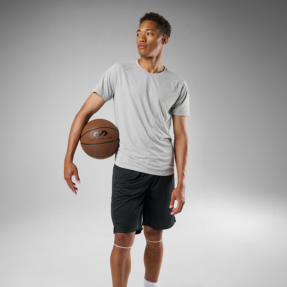 McDavid Silicone Patella Band Pair - White - Shown on Model holding Basketball