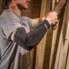 Lifestyle Image of Contractor Using Hammer While Wearing McDavid Pro-Force Compression Arm Sleeve with Abrasion Fabric