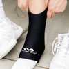 McDavid Flex Ice Therapy Ankle Compression Sleeve - Lifestyle Image  - Athlete Sliding Sleeve Over Ankle