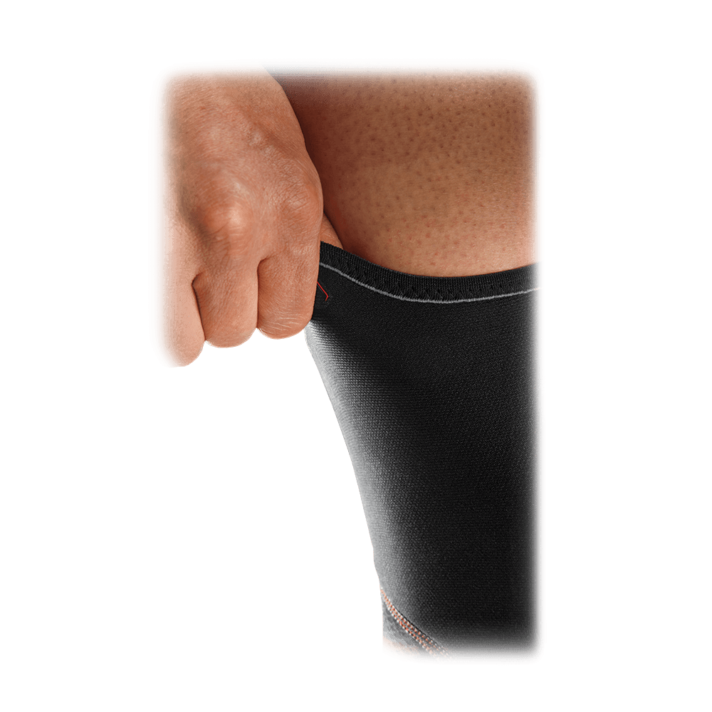 McDavid Knee Support with Sorbothane® Pad shown being pulled on